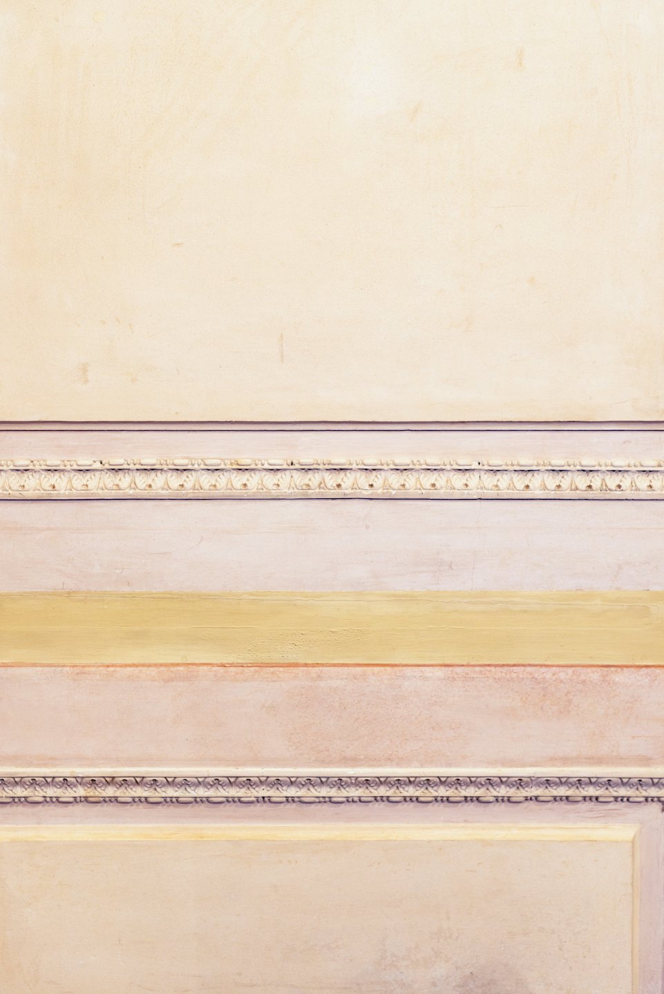 Parete materica con fasce orizzontali di intonaco e pittura.