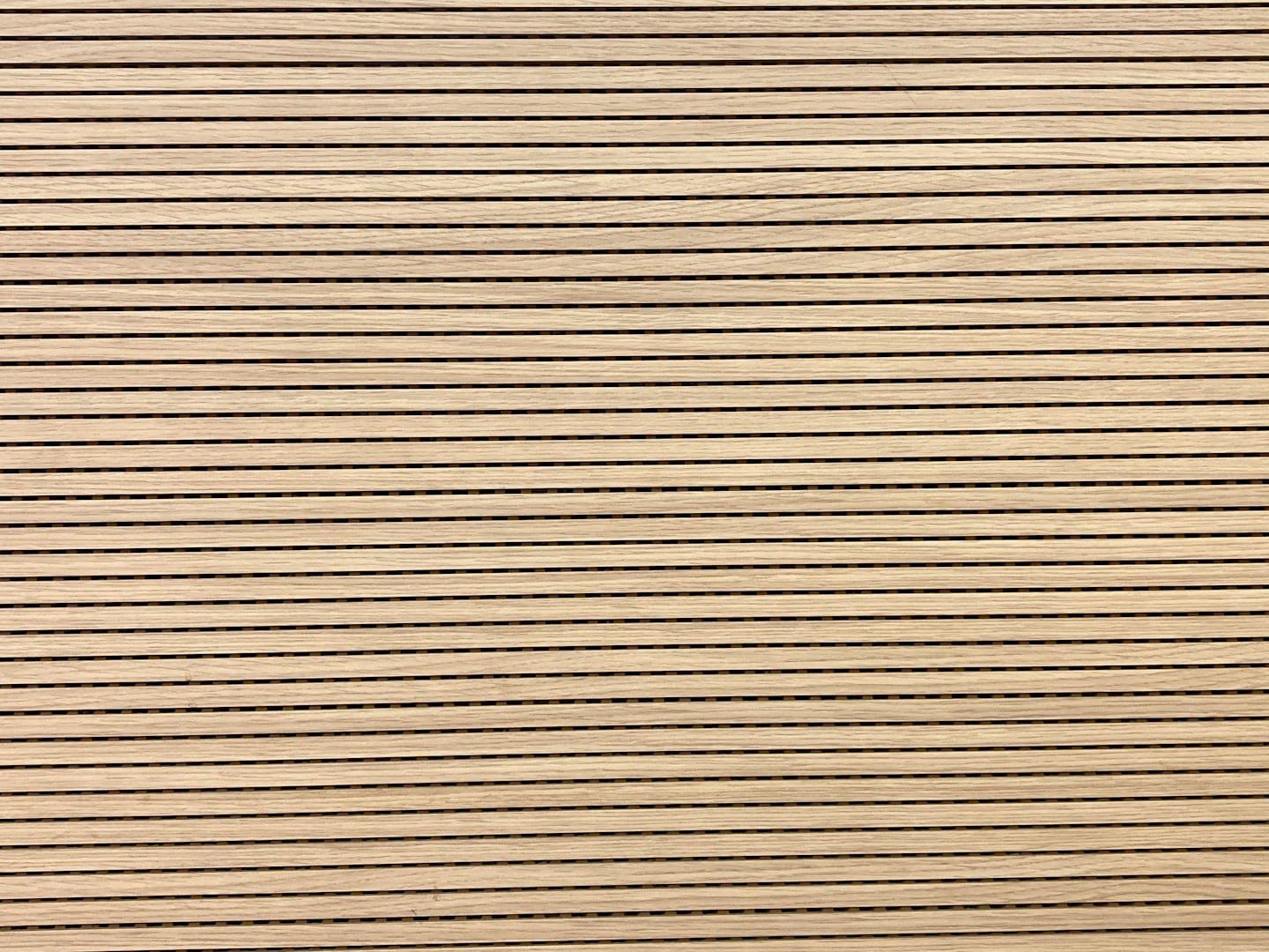 Listelli orizzontali in legno chiaro su una parete acustica.